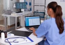 female health care provider looking at computer, back to camera